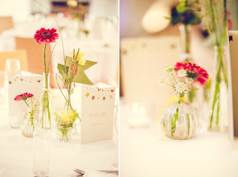 Inspiration für eine Tischdeko im Vintage-Stil mit kleinen Glasvasen und roten und gelben Blumen. Foto: Stefanie Danner.