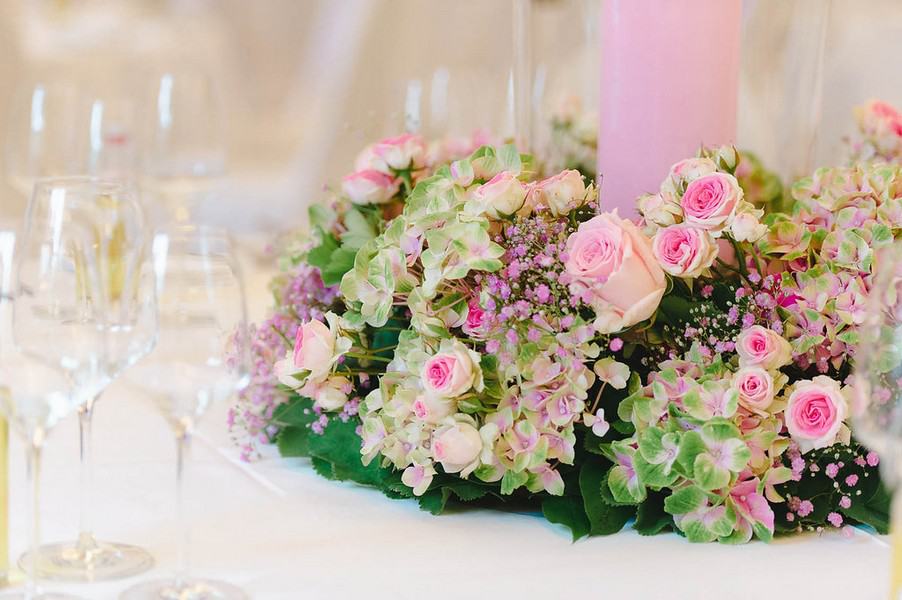 Tischdeko für eine Hochzeit als Gesteck in rosa, pink und weiß