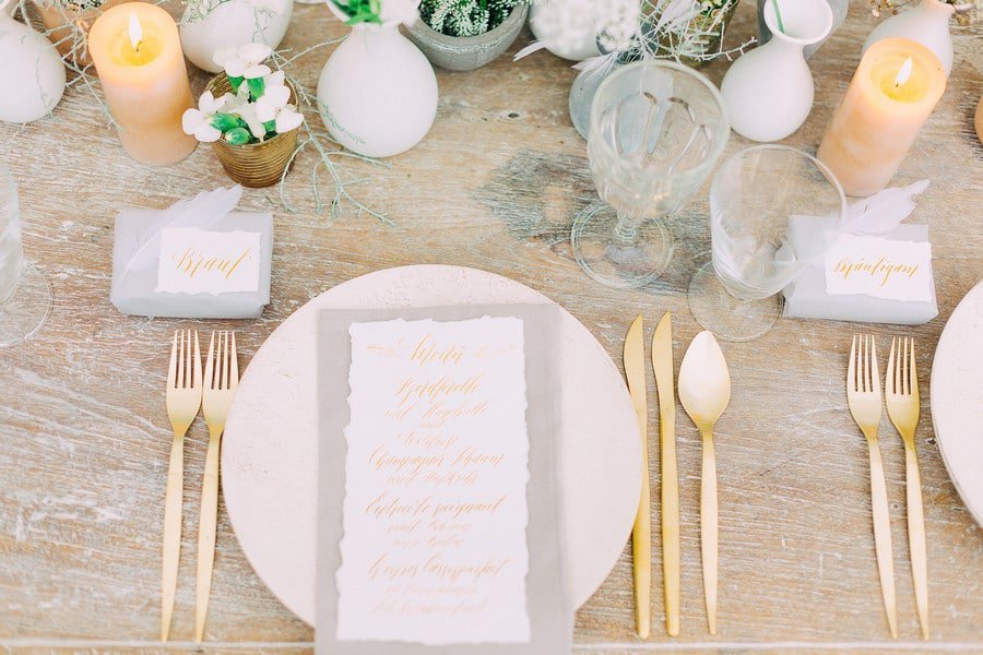 Tischdeko für eine Hochzeit in Weiß, Gold, Grau und Beige mit Federn