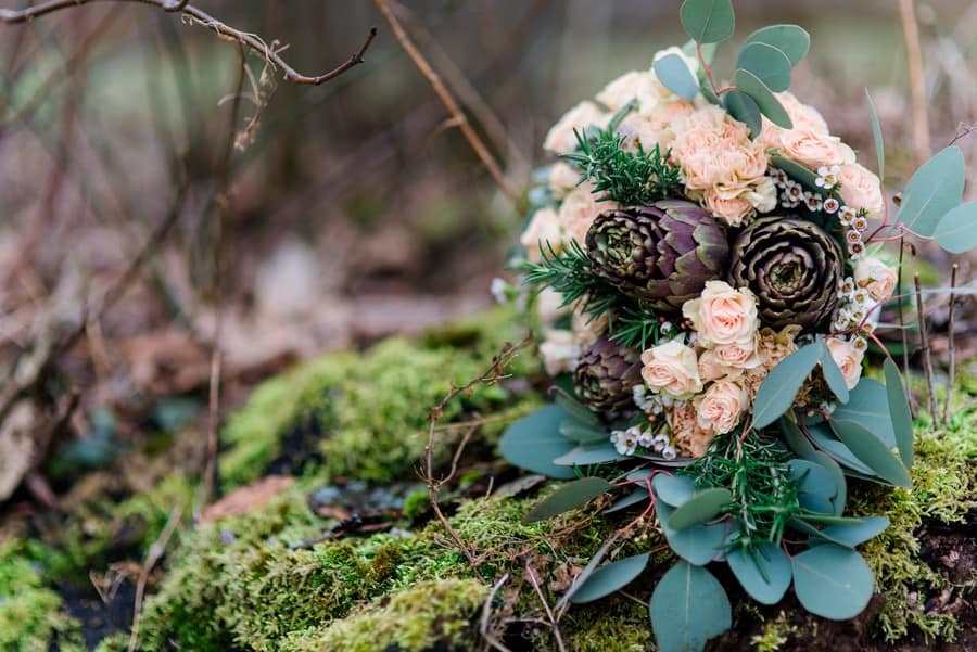 Ein natürlich-winterlicher Brautstrauß in Blassrosa, Peach und Grün, mit Artischocken und Eukalyptus-Blättern
