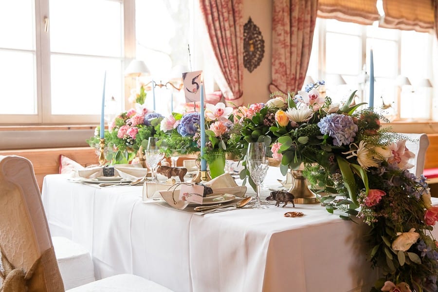 Üppiger Boho-Blumenschmuck für eine Hochzeitstafel