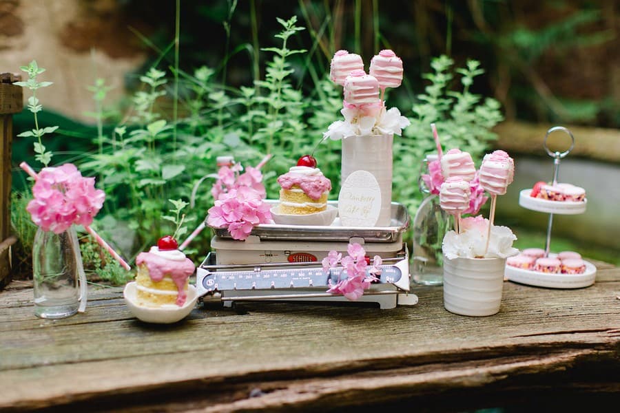 Ideen für Süßigkeiten, Obst wie Kirschen und Melonen, Gebäck, Cupcakes und Macarons für den Sweet-Table einer Hochzeit. Farbthema: Rosa, Weiß, Lila.