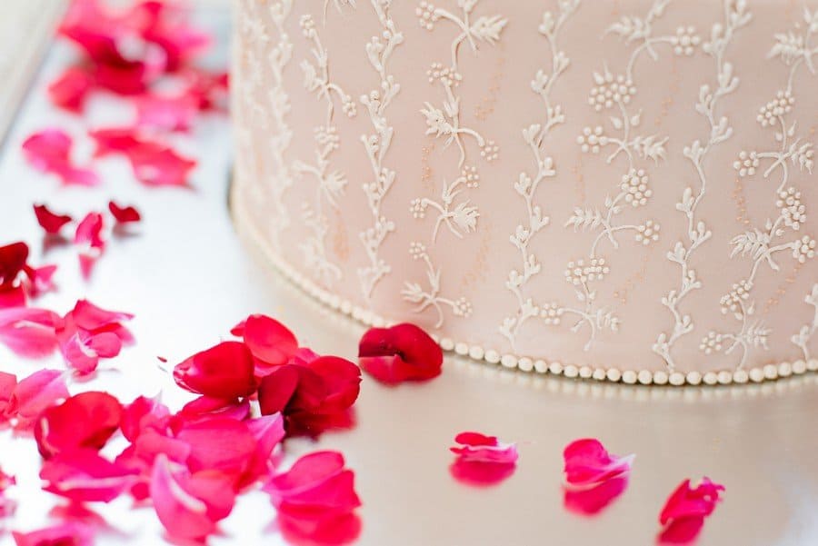 Kunstvolle Hochzeitstorte mit zarter Verzierung in blush und Weiß