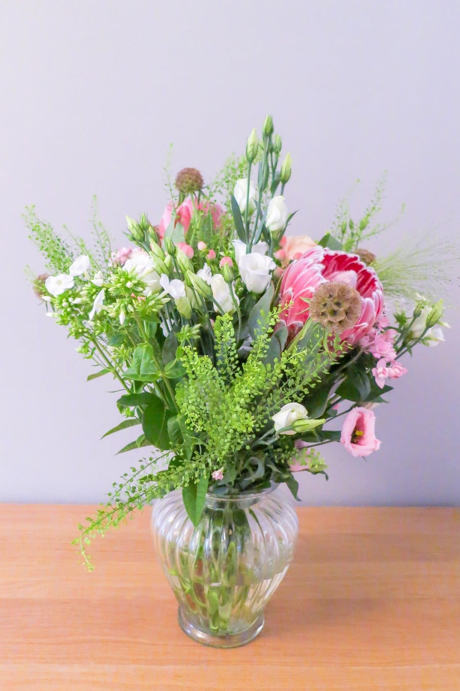 Hochzeit mit Protea. Blumen in einzelnen Vasen in Rosa und Weiß. Konzept von Hochzeitsgezwitscher