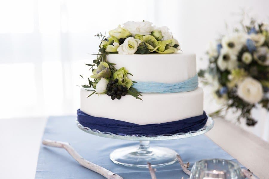 Kleine Hochzeitstorte passend zu einer Frühlingshochzeit in Blau, Weiß und grünen Blumen